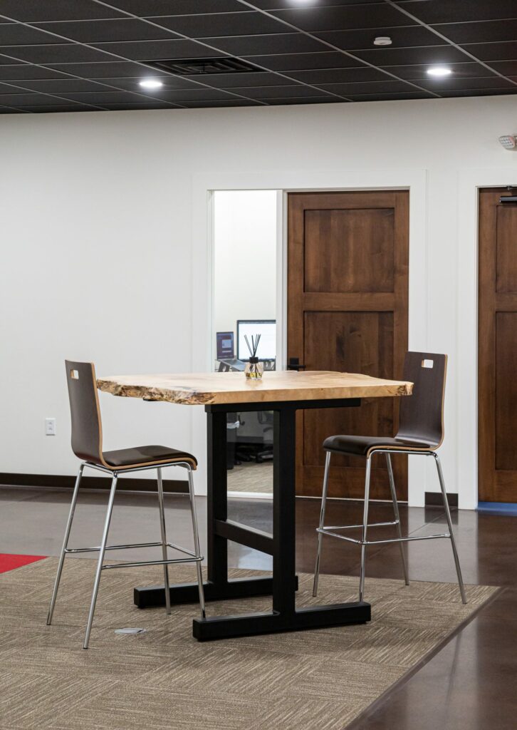 Counter height live edge table and chairs in office building